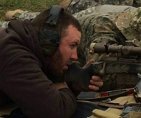 Matt Roberts looking down the scope of a rifle