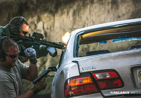 Matt Roberts and another SWAT operator performing live fire training near a car